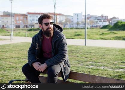 Young men with hipster look sitting on a bench in street