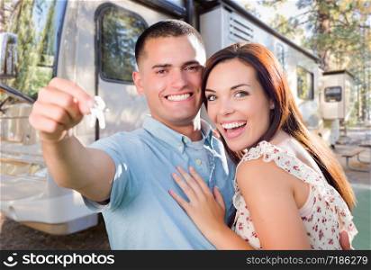 Young Military Couple Holding Keys In Front of New RV.