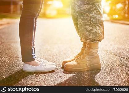 Young military couple kissing each other, homecoming concept, soft focus,warm orange toning applied