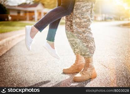 Young military couple kissing each other, homecoming concept, warm orange toning applied