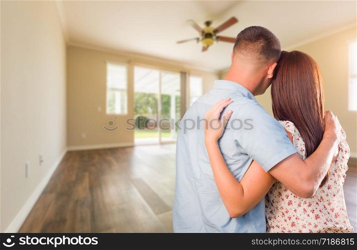Young Military Couple Looking At Empty Room of New House.