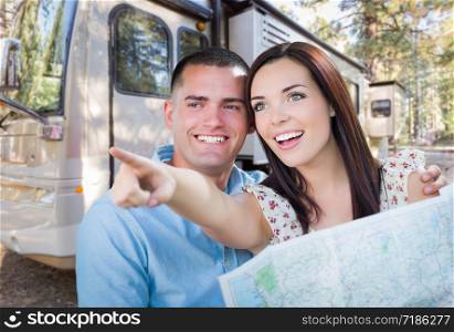 Young Military Couple Looking at Map In Front of RV.