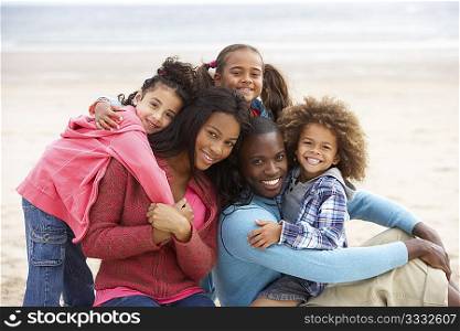 Young mixed race family embracing on beach