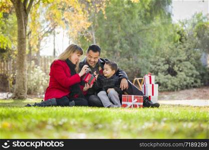 Young Mixed Race Family Enjoying Christmas Gifts in the Park Together.