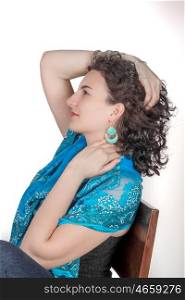Young model in her mid twenties wearing aqua colored earrings of middle eastern design and a blue shawl.