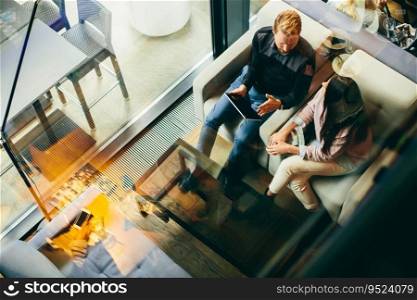 Young modern couple sitting together and using a tablet, view from above