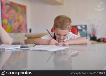 young mom woman doing home work with elementary school grade boy at home in kitchen