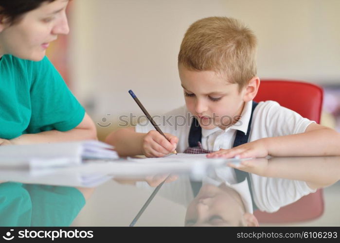 young mom woman doing home work with elementary school grade boy at home in kitchen