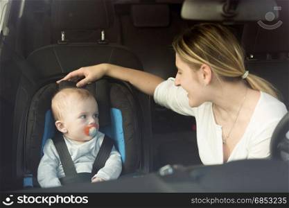 Young mother and baby in car child seat