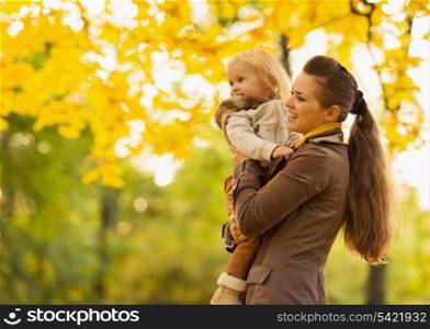 Young mother and baby looking on copy space