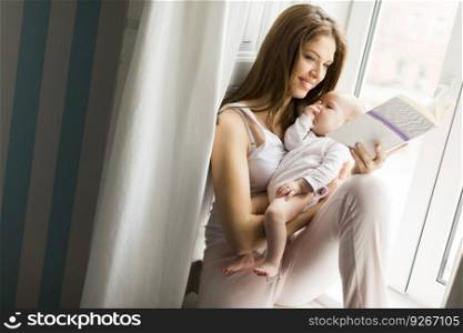 Young mother and cute baby girl in the room