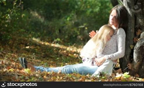 Young mother and daughter having a great sunny day in the park, talking