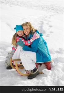 Young Mother And Daughter With A Sled In The Snow