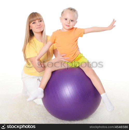 young mother and her little daughter doing sport together indoors