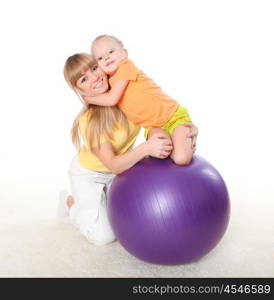 young mother and her little daughter doing sport together indoors