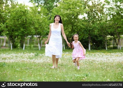 Young mother and her young daughter fun time together outdoors.