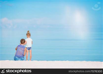 Young mother and little cute daughter on the beach. Beautiful mother and daughter on the beach enjoying summer vacation.