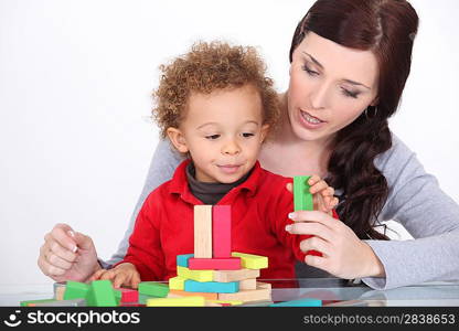 young mother and little son playing with construction set