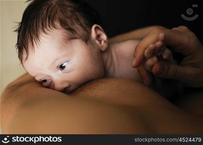Young mother breastfeeding newborn baby at home