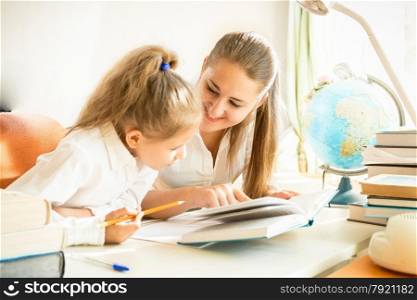 Young mother helping daughter with homework
