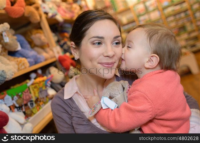 young mother her daughter shopping at the toy store
