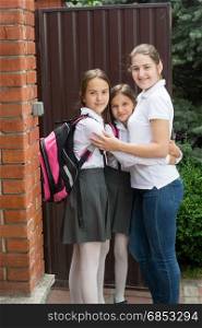 Young mother hugging daughters before they leaving for school