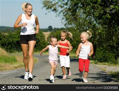 young mother jogging with her three little daughters