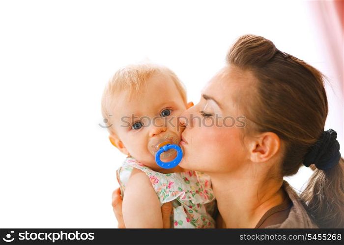 Young mother kissing baby with soother&#xA;