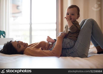 Young mother playing with her baby at home