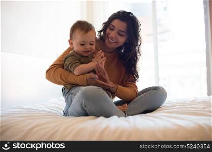 Young mother playing with her baby at home