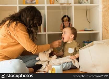 Young Mother playing with toddler at home