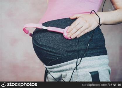 Young mother put music to her baby in her belly during pregnancy