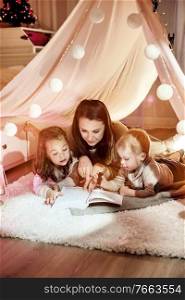 Young mother reading a novel with her children