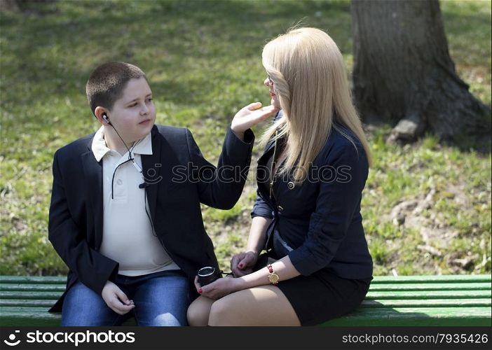 young mother talks to the child, sitting on a bench