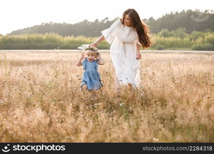 Young mother walking with her litt≤daughter in the gold field. Family holiday in garden, park. Portrait mom withχld to≥ther on nature. Mum, litt≤daughter outdoors. Happy Mothers Day. Close up.. Young mother walking with her litt≤daughter in the gold field. Family holiday in garden, park. Portrait mom withχld to≥ther on nature. Mum, litt≤daughter outdoors. Happy Mothers Day. Close up