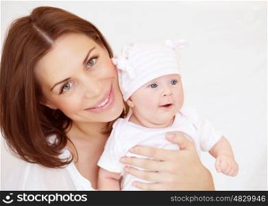Young mother with baby boy at home, funny toddler, enjoying family, healthy and happy lifestyle, loving embracing of mommy