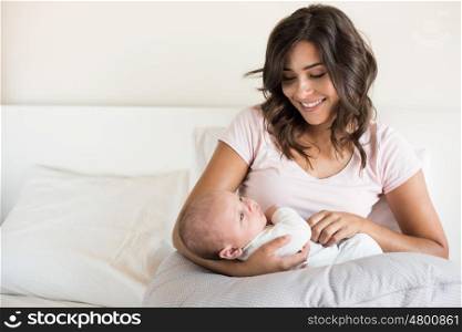 Young mother with baby in bed