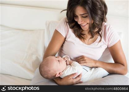 Young mother with baby in bed