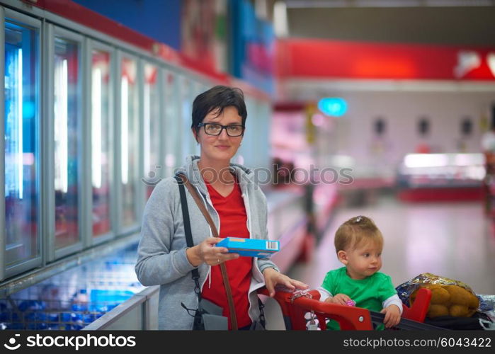 young mother with baby in shopping mall supermarket store buying food and grocery