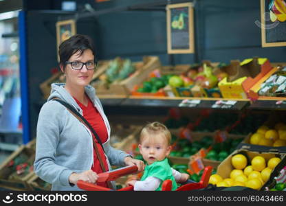 young mother with baby in shopping mall supermarket store buying food and grocery