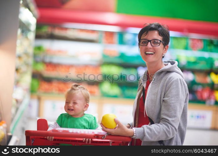 young mother with baby in shopping mall supermarket store buying food and grocery