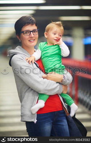 young mother with baby in shopping mall supermarket store buying food and grocery