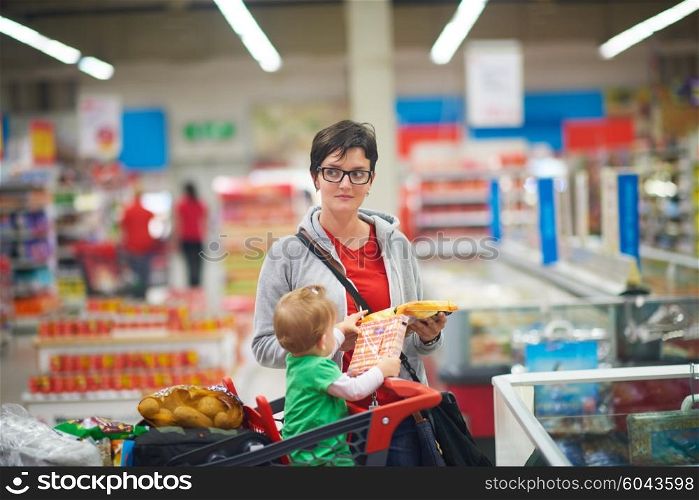 young mother with baby in shopping mall supermarket store buying food and grocery