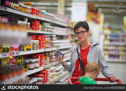 young mother with baby in shopping mall supermarket store buying food and grocery