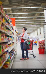 young mother with baby in shopping mall supermarket store buying food and grocery