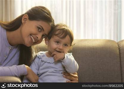 Young mother with baby looking away together 