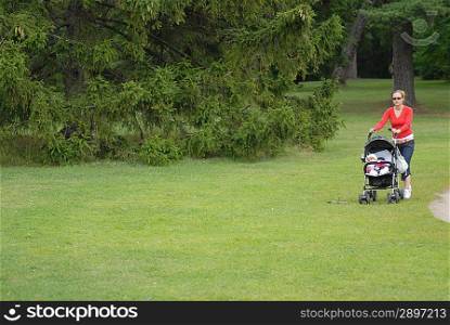 Young mother with child goes on grass