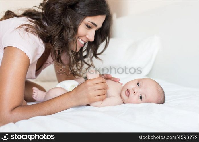 Young mother with her baby in bed