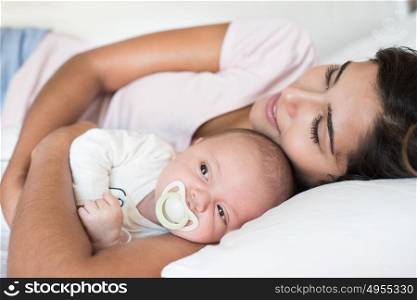 Young mother with her baby in bed