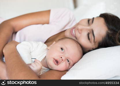 Young mother with her baby in bed